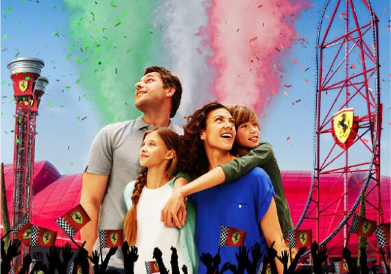 Familia disfrutando del GP Festival en Ferrari Land, con las atracciones y la decoración Ferrari al fondo