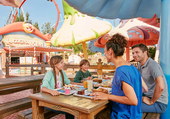 Familia disfrutando de una comida en un restaurante temático de PortAventura World