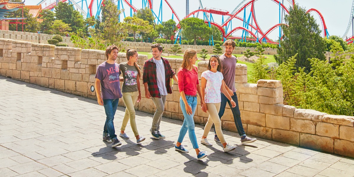 Grupo de amigos paseando y sonriendo por PortAventura Park
