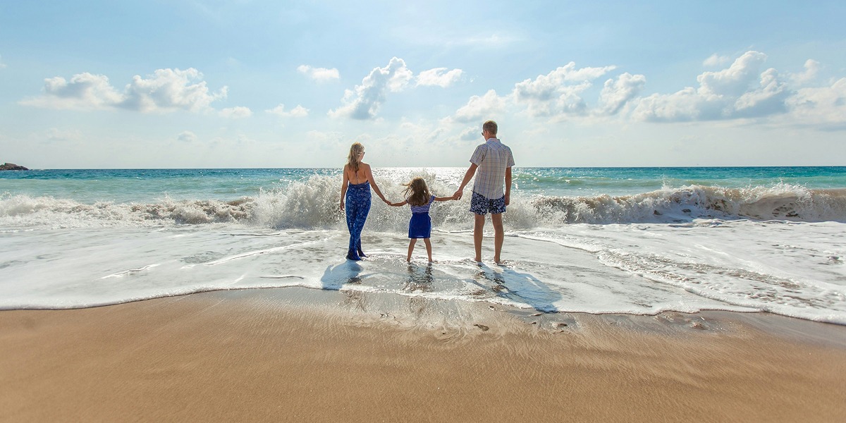 Familia paseando por la orilla del mar en la Costa Dorada