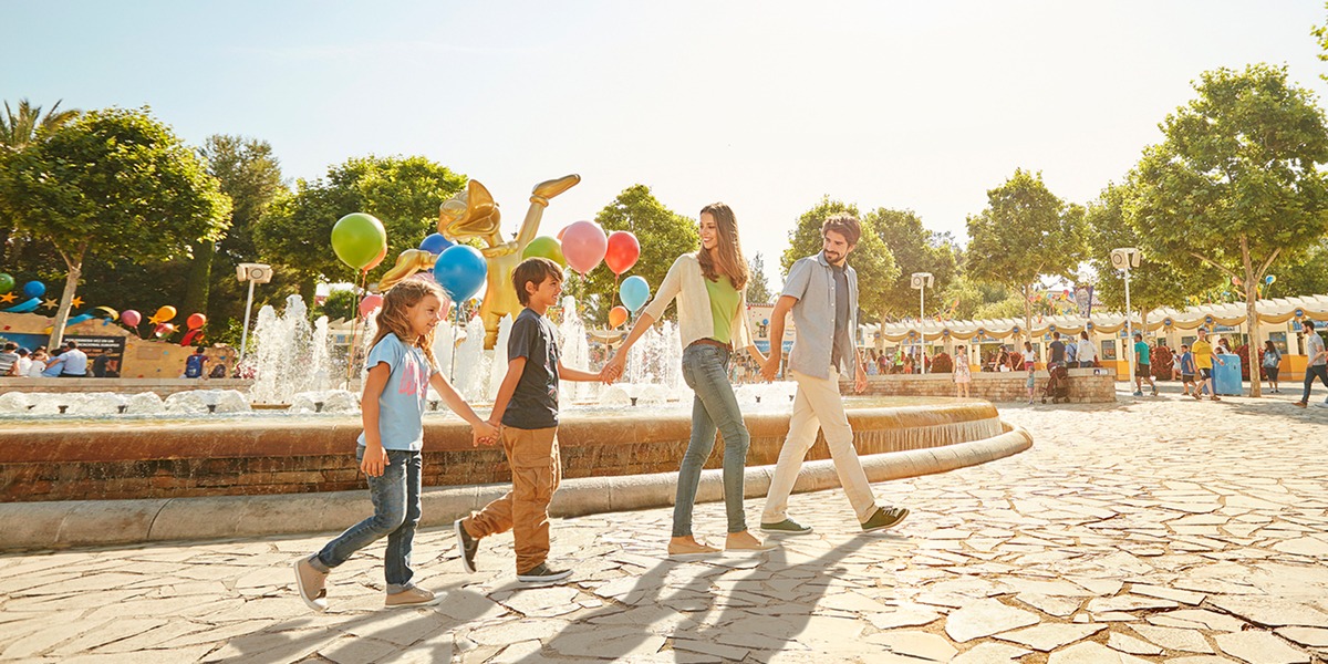 Familia paseando con globos de colores en PortAventura World